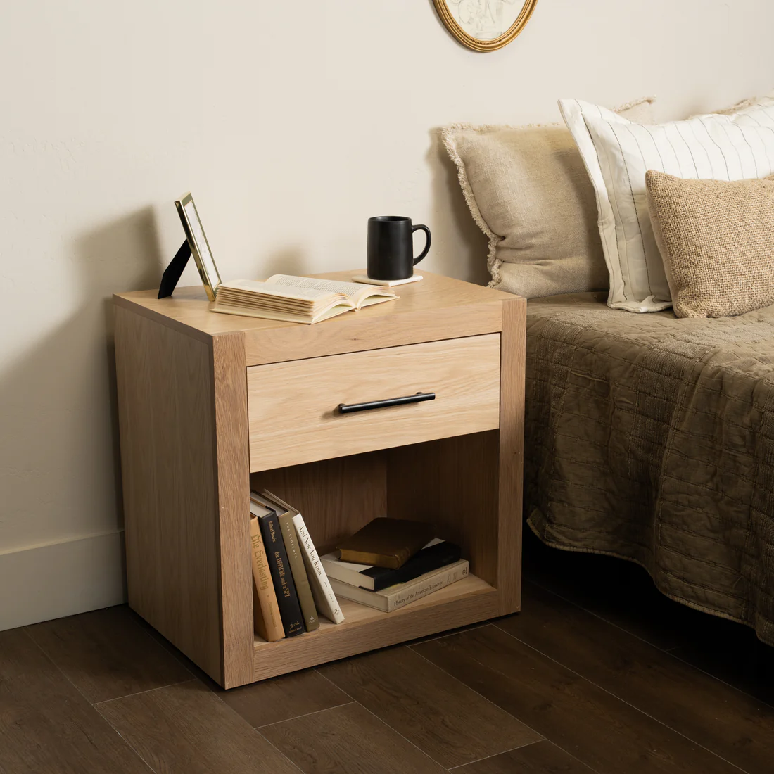 Modern Murphy Concealment Nightstand by Murphy Door®, light wood with a drawer & shelf, styled with books & mug.