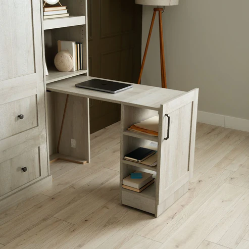 Murphy Door® light wood desk with laptop, built-in shelving, and seamless integration with cabinet storage system